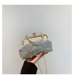 Detail of vintage blue jacquard clutch bag with metal ring handle and clip closure