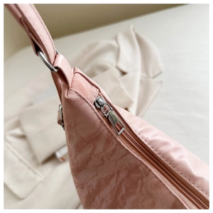 Détail du sac cabas rose avec texture plissée, fermeture éclair et anneaux métalliques