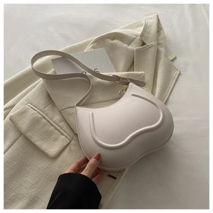 Detail of heart-shaped cream PU leather shoulder bag with gold buckle and adjustable strap