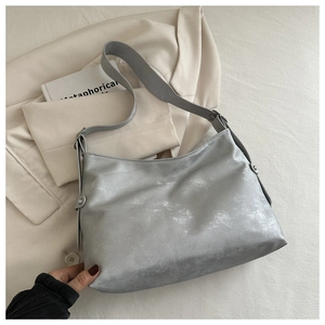 Detail view of silver hobo bag with vintage brushed texture and wide shoulder strap