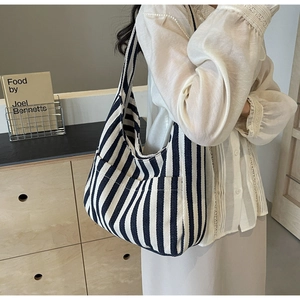 Detail of striped canvas tote bag showing side functional pocket and durable knit texture