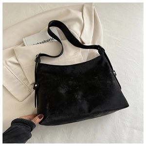 Detail of black tote bag featuring silver metal buckle and reinforced rivets on the side