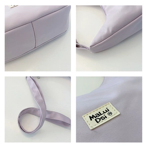 Detail of light purple nylon shoulder bag showing stitching, base, and brand label
