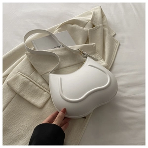 Detail of white minimalist underarm bag with curved lines on a stylish blazer