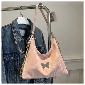 Détail du sac bandoulière plissé rose avec papillon argenté et bandoulière chaîne