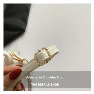 Detail of adjustable white leather shoulder strap with gold buckle and precise stitching