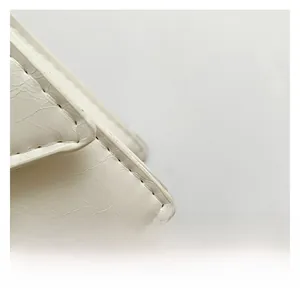 Detailed close-up of white leather texture with stylish gathered pleats and fine stitching