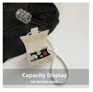 Internal view of a minimalist white crossbody bag showing capacity for lipstick and perfume