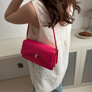 Minimalist rose pink leather crossbody bag with gold buckle shown on shoulder back view