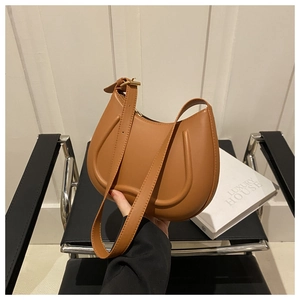 Close-up of brown crescent underarm bag with gold metal buckle and smooth leather finish