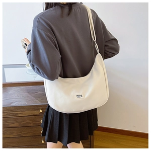 Back view of a white crescent canvas saddle bag with adjustable shoulder strap