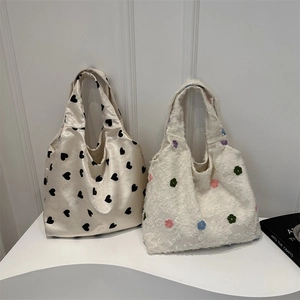Sacs à main en tricot avec motifs de cœurs et fleurs brodées sur un support moderne