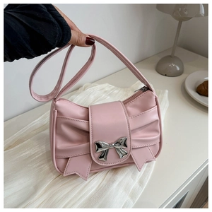 Detail of pink bow-shaped PU leather handbag with silver metallic bow clasp detail