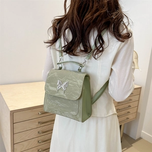 Mini light green backpack with butterfly buckle and crinkled faux leather texture