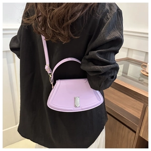 Back view of a trendy purple crossbody bag with unique curved base and sleek metal lock