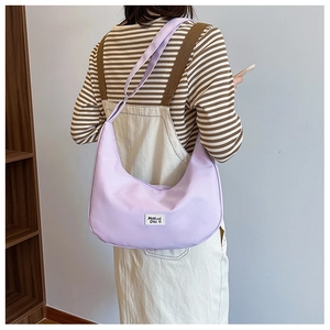 Detail shot of the light purple nylon half-moon bag worn as a casual shoulder strap crossbody