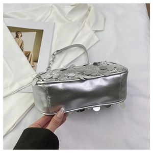 Close-up of silver sequin shoulder bag with metallic leather detail and chain strap