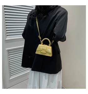 Detail of a bright yellow mini crossbody bag shown from behind on a model outfit