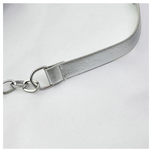 Detailed macro view of silver crinkled leather strap with polished metal rings and chain link