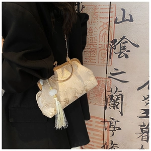 Close-up of vintage silk bag with golden flower embroidery and beaded long tassel