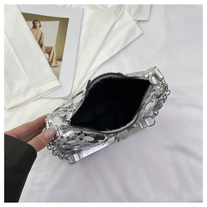 Close-up of silver sequin handbag featuring metallic chain detail and black zipper closure