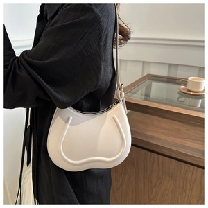 Chic white leather half-moon underarm bag styled with a black textured shirt for women