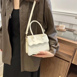 Minimalist white crossbody bag with scalloped flap and gold hardware for women