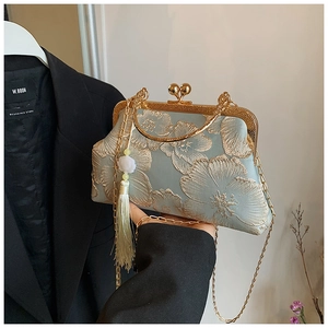 Detail of light blue silk evening bag with gold floral embroidery and tassel charm