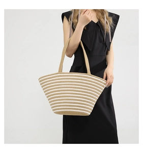 Vue détaillée du tissage et des rayures beige-blanc d'un grand sac cabas en paille