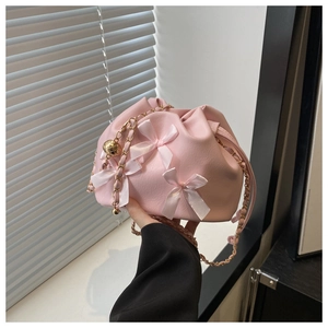 Detail der rosa Bucket Bag mit Satinschleifen, Kordelzug und goldener Kettenschultergurt