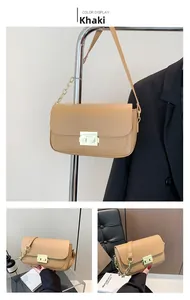 Detail view of khaki rectangular bag with gold metal clasp and chain shoulder strap