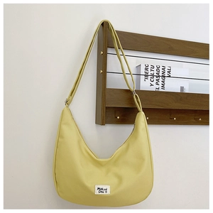 Detail showing the lemon yellow waterproof nylon hobo bag and woven brand label