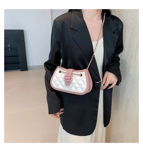Chic pink and white quilted crossbody bag worn by a model in elegant office attire