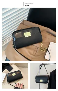 Detail of black leather baguette bag with golden metal buckle and chunky chain strap