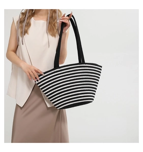 Détail du sac cabas tissé à rayures noires et blanches avec de grandes anses et une grande capacité
