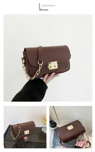 Detail of vintage brown leather handbag featuring a gold twist lock and chain strap