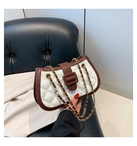 Detail of quilted leather small square bag with contrast trim and woven chain strap