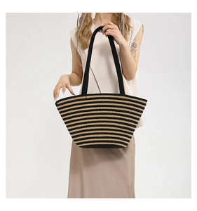 Détail montrant la texture tissée et le motif rayé noir et jaune du sac fourre-tout