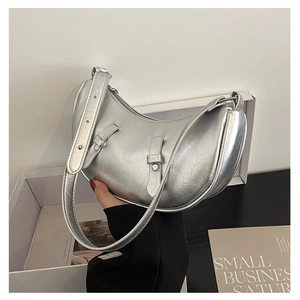 Detail of silver crescent bag with metallic cracked texture and wide shoulder strap