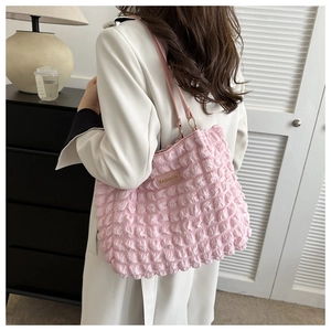 Détail du sac plissé rose avec texture 3D à bulles et une boucle en métal doré