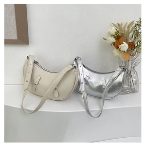 Detail of crescent bags in cream smooth leather and metallic silver cracked texture