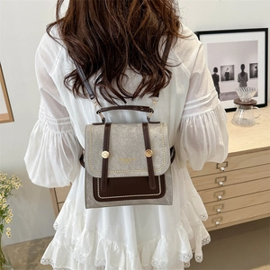 Retro academic style beige backpack with brown leather trim and metallic gold accents