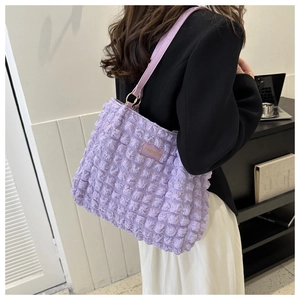 Gros plan détaillé sur le sac violet à texture bulle avec anneau doré élégant sur la sangle