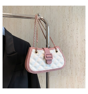 Detail of pink and white quilted crossbody bag with metal chain strap on display