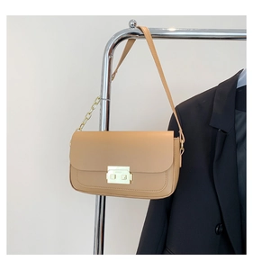 Detail view of khaki leather baguette bag with gold metal clasp and chain strap