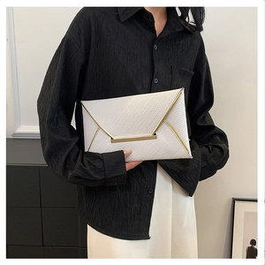 Détail de la pochette enveloppe blanche avec texture tissée en V et bords dorés fins