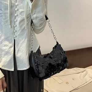 Chic black sequin shoulder bag with silver metal chain strap shown on model's shoulder