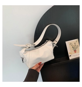 Close-up of minimalist white PU leather shoulder bag with sleek silver buckle and zipper