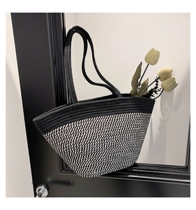Détail d'un sac cabas tissé noir et blanc avec poignées solides et décor de tulipe