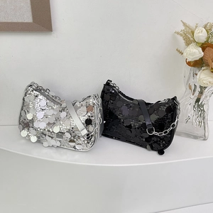 Chic silver and black sequined handbags with metallic chain straps on white display stand
